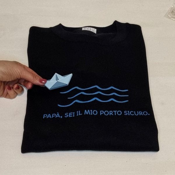 T-shirt e Felpa "Papà sei il mio porto sicuro" con spilla in legno artigianale Un regalo originale e pieno di significato per il tuo papà: t-shirt e felpa personalizzate con la frase "Papà sei il mio porto sicuro" e una spilla in legno a forma di barca, realizzata a mano. Perfette per la Festa del Papà, compleanni o qualsiasi occasione speciale, sono un modo unico per dire "grazie" a chi è sempre stato il tuo punto fermo. Qualità, creatività e tanto amore in un solo prodotto. Scopri tutte le taglie e i colori disponibili e sorprendi tuo papà con un dono unico! Tag utili felpa papà, t-shirt papà, idea regalo festa del papà, regalo originale papà, t-shirt personalizzata papà, felpa personalizzata papà, spilla barca legno, regalo emozionante papà