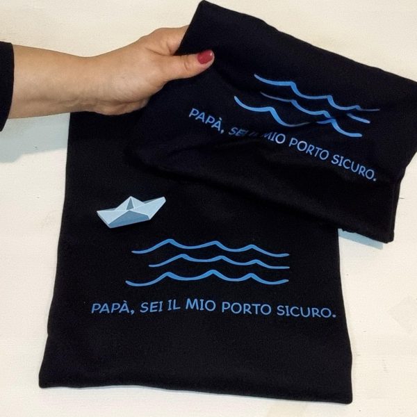T-shirt e Felpa "Papà sei il mio porto sicuro" con spilla in legno artigianale Un regalo originale e pieno di significato per il tuo papà: t-shirt e felpa personalizzate con la frase "Papà sei il mio porto sicuro" e una spilla in legno a forma di barca, realizzata a mano. Perfette per la Festa del Papà, compleanni o qualsiasi occasione speciale, sono un modo unico per dire "grazie" a chi è sempre stato il tuo punto fermo. Qualità, creatività e tanto amore in un solo prodotto. Scopri tutte le taglie e i colori disponibili e sorprendi tuo papà con un dono unico! Tag utili felpa papà, t-shirt papà, idea regalo festa del papà, regalo originale papà, t-shirt personalizzata papà, felpa personalizzata papà, spilla barca legno, regalo emozionante papà