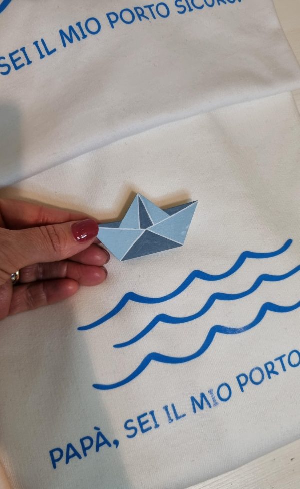 T-shirt e Felpa "Papà sei il mio porto sicuro" con spilla in legno artigianale Un regalo originale e pieno di significato per il tuo papà: t-shirt e felpa personalizzate con la frase "Papà sei il mio porto sicuro" e una spilla in legno a forma di barca, realizzata a mano. Perfette per la Festa del Papà, compleanni o qualsiasi occasione speciale, sono un modo unico per dire "grazie" a chi è sempre stato il tuo punto fermo. Qualità, creatività e tanto amore in un solo prodotto. Scopri tutte le taglie e i colori disponibili e sorprendi tuo papà con un dono unico! Tag utili felpa papà, t-shirt papà, idea regalo festa del papà, regalo originale papà, t-shirt personalizzata papà, felpa personalizzata papà, spilla barca legno, regalo emozionante papà
