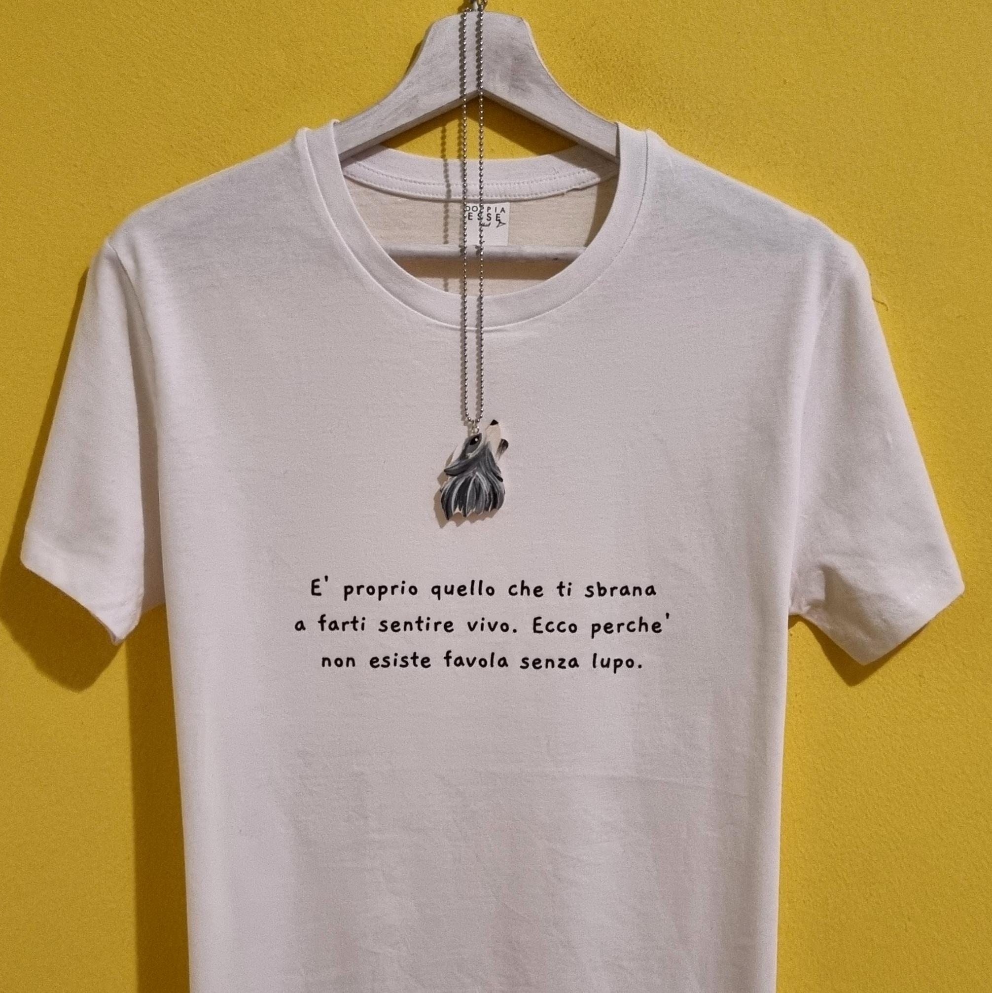 Scopri la nostra t-shirt dedicata alla favola più iconica di sempre, reinterpretata con un tocco moderno, intenso e ironico. La frase stampata – “È proprio quello che ti sbrana a farti sentire vivo. Ecco perché non esiste favola senza lupo.” – parla di forza, coraggio e di quella scintilla che rende ogni storia davvero degna di essere vissuta. Questa maglietta è realizzata in cotone morbido, disponibile sia in bianco che in nero, e viene accompagnata da una collanina con ciondolo a forma di lupo, perfetta per completare il mood della storia. Un capo pensato per chi ama le fiabe, i simboli, la libertà e un pizzico di carattere selvaggio. Ideale come regalo, come capo significativo da indossare in una giornata speciale o come pezzo da collezione per chi ama il mondo delle favole rivisitate. La t-shirt appartiene alla nostra linea dedicata alle fiabe reinterpretate: un mix tra moda, storytelling e accessori artigianali che rendono ogni maglietta unica. Caratteristiche principali: Cotone di alta qualità Stampa resistente e definita Collanina con ciondolo lupo inclusa Disponibile in bianco o nero Idea regalo perfetta per chi ama fiabe, simboli e significati Aggiungi un tocco di magia alla tua storia: scegli la tua versione del lupo e indossa una favola che parla anche un po’ di te.