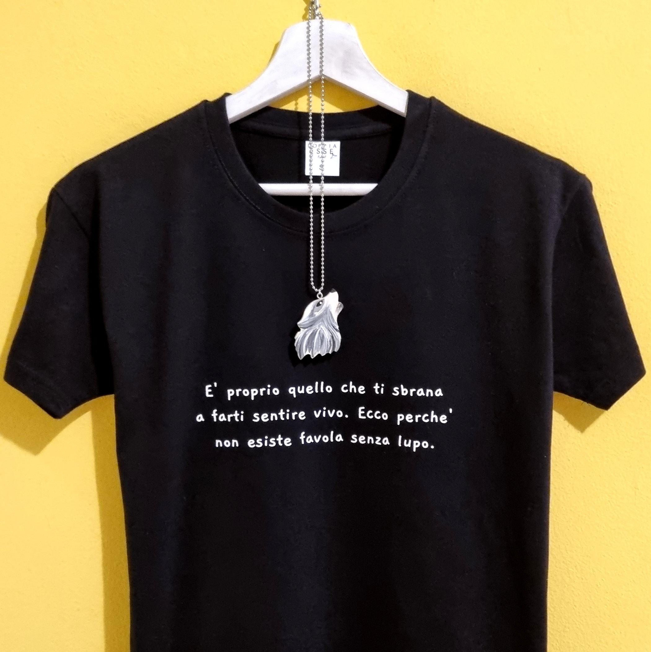 Scopri la nostra t-shirt dedicata alla favola più iconica di sempre, reinterpretata con un tocco moderno, intenso e ironico. La frase stampata – “È proprio quello che ti sbrana a farti sentire vivo. Ecco perché non esiste favola senza lupo.” – parla di forza, coraggio e di quella scintilla che rende ogni storia davvero degna di essere vissuta. Questa maglietta è realizzata in cotone morbido, disponibile sia in bianco che in nero, e viene accompagnata da una collanina con ciondolo a forma di lupo, perfetta per completare il mood della storia. Un capo pensato per chi ama le fiabe, i simboli, la libertà e un pizzico di carattere selvaggio. Ideale come regalo, come capo significativo da indossare in una giornata speciale o come pezzo da collezione per chi ama il mondo delle favole rivisitate. La t-shirt appartiene alla nostra linea dedicata alle fiabe reinterpretate: un mix tra moda, storytelling e accessori artigianali che rendono ogni maglietta unica. Caratteristiche principali: Cotone di alta qualità Stampa resistente e definita Collanina con ciondolo lupo inclusa Disponibile in bianco o nero Idea regalo perfetta per chi ama fiabe, simboli e significati Aggiungi un tocco di magia alla tua storia: scegli la tua versione del lupo e indossa una favola che parla anche un po’ di te.