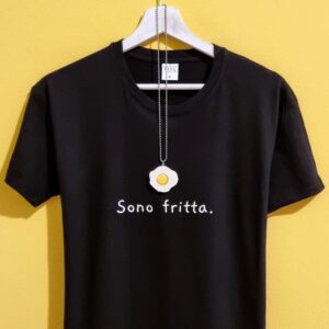 La maglietta perfetta per chi ha la testa… a padella! La t-shirt “Sono frittə” è realizzata in cotone morbido e arriva con una collanina adorabile a forma di uovo al tegamino: un mix irresistibile di ironia, stile e autoironia. Ideale per chi ama ridere, per chi è sempre di corsa o per chi vuole un look leggero e super originale. Un’idea regalo divertente e un capo unico nella tua collezione food-style. Caratteristiche: Cotone morbido Stampa ironica Collanina uovo inclusa Idea regalo perfetta Sceglila se oggi… ti senti fritta. 😄🍳