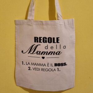 Cerchi un’idea regalo originale per la Festa della Mamma? Qui trovi magliette, shopper e grembiuli personalizzati con frasi ironiche, dolci e super rappresentative… perché diciamolo: la mamma è sempre il boss 😎 Le nostre t-shirt per la mamma sono perfette per sorprendere con un regalo unico, divertente e pieno di significato. Dalle frasi simpatiche come “Regole della Mamma” ai design più emozionali come “Grazie Mamma”, ogni prodotto è pensato per far sorridere (o commuovere, dipende dal carattere della mamma 👀). Puoi scegliere tra: Magliette personalizzate per la mamma Shopper e borse regalo originali Grembiuli divertenti per mamme regine della cucina Ideali per la Festa della Mamma, ma anche per compleanni o semplicemente per dire “ti voglio bene” in modo diverso dal solito. Tutti i prodotti sono realizzati nel nostro laboratorio creativo con cura artigianale e possibilità di personalizzazione.