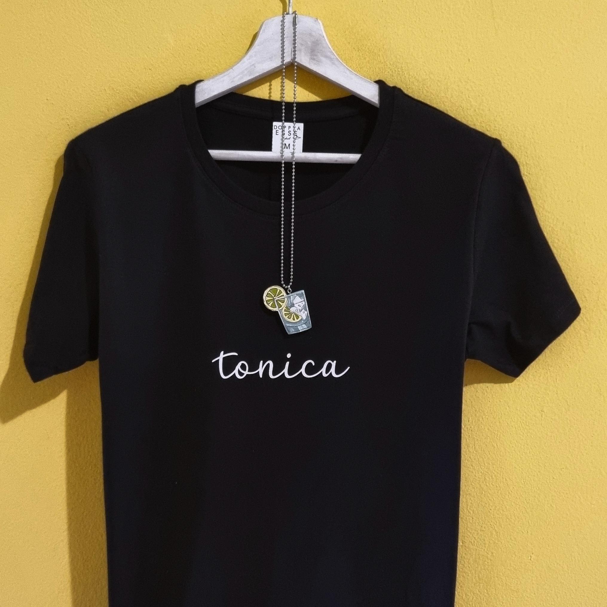 T-shirt Spritz e Gin Tonic – Magliette divertenti con collanina abbinata Se ami gli aperitivi, le serate in compagnia e l'ironia, queste t-shirt sono fatte per te. Le magliette Spritz e Gin Tonic di Doppia Esse uniscono una scritta minimal a una simpatica collanina a forma di cocktail, creando un originale effetto rebus che conquista al primo sguardo. Perfette per chi non rinuncia mai a un brindisi con gli amici, sono un'idea regalo originale per compleanni, addii al nubilato, feste, vacanze, aperitivi e per tutti gli amanti dello Spritz e del Gin Tonic. Disponibili in diversi colori, sono realizzate in cotone di qualità e stampate nel nostro laboratorio artigianale. Un regalo divertente, diverso dal solito e perfetto per chi ama indossare la propria personalità... con un pizzico di ironia.