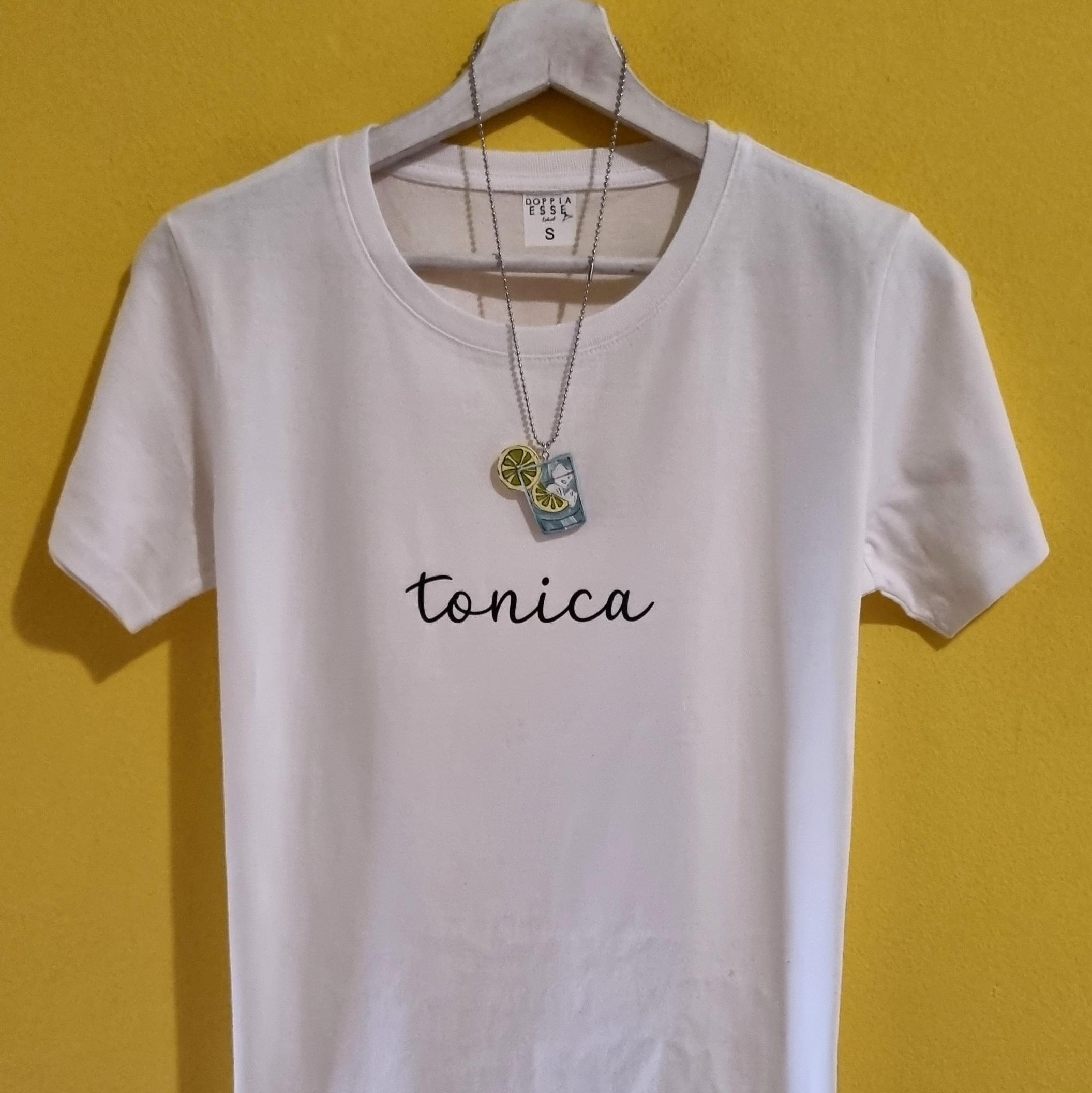T-shirt Spritz e Gin Tonic – Magliette divertenti con collanina abbinata Se ami gli aperitivi, le serate in compagnia e l'ironia, queste t-shirt sono fatte per te. Le magliette Spritz e Gin Tonic di Doppia Esse uniscono una scritta minimal a una simpatica collanina a forma di cocktail, creando un originale effetto rebus che conquista al primo sguardo. Perfette per chi non rinuncia mai a un brindisi con gli amici, sono un'idea regalo originale per compleanni, addii al nubilato, feste, vacanze, aperitivi e per tutti gli amanti dello Spritz e del Gin Tonic. Disponibili in diversi colori, sono realizzate in cotone di qualità e stampate nel nostro laboratorio artigianale. Un regalo divertente, diverso dal solito e perfetto per chi ama indossare la propria personalità... con un pizzico di ironia.